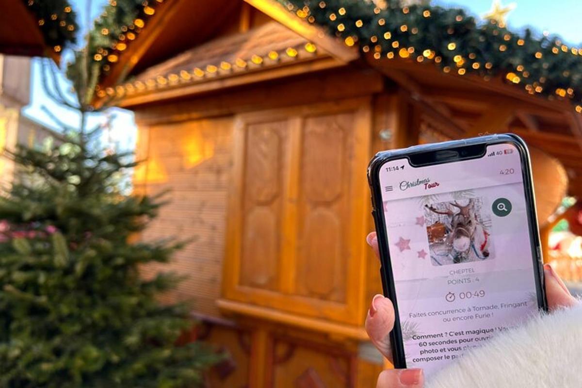 oseba, ki drži mobilni telefon pred hišo