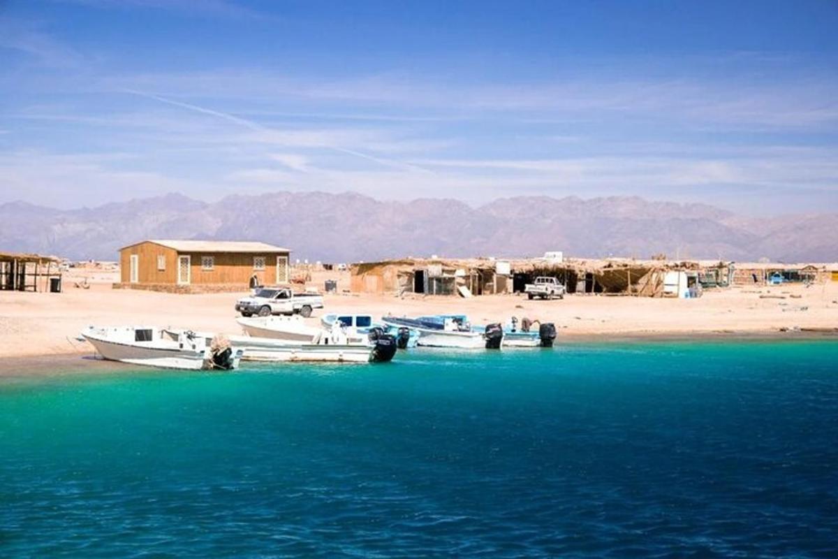 due barche sono attraccate su una spiaggia vicino all'acqua
