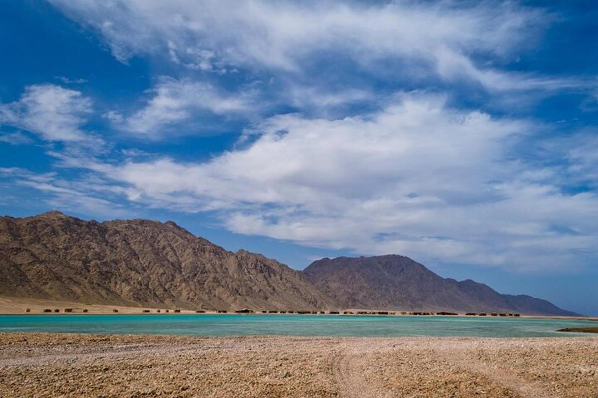 uno specchio d'acqua con le montagne sullo sfondo