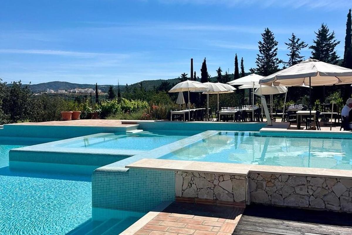 una grande piscina con tavoli e ombrelloni
