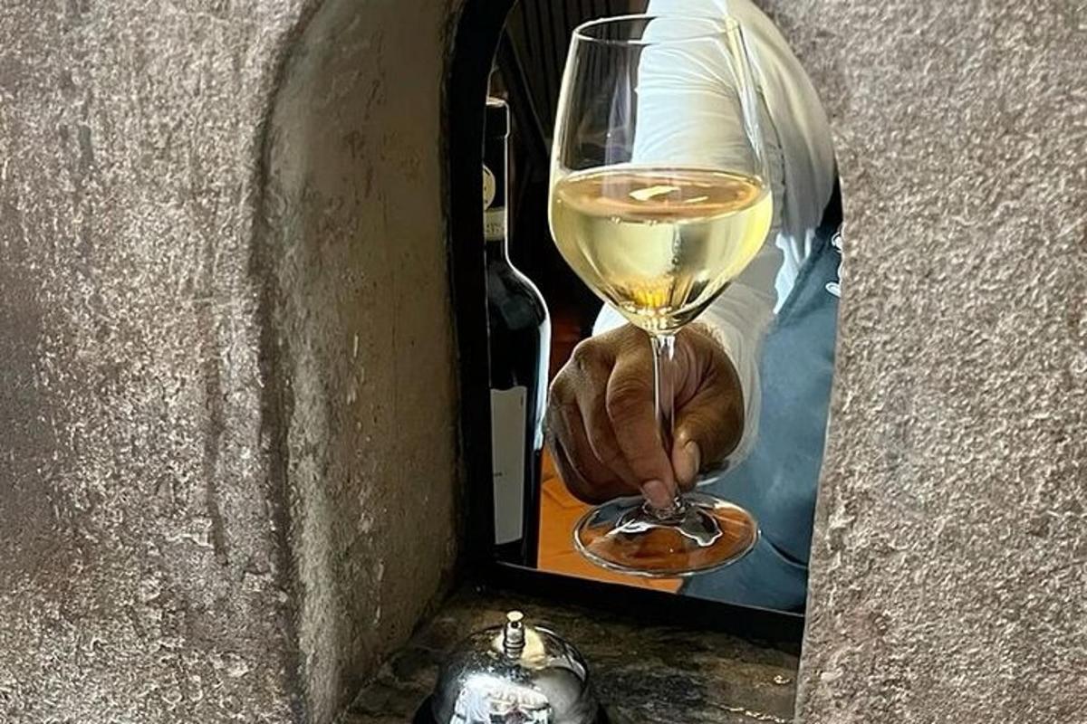 osoba držící sklenici bílého vína