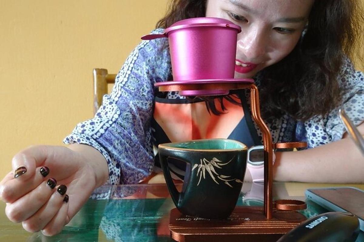 una mujer sentada en una mesa con una cafetera