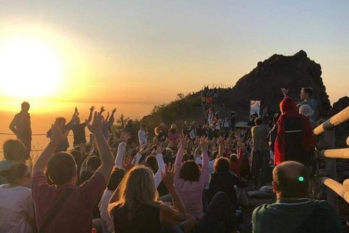 dav lidí sledujících koncert při západu slunce