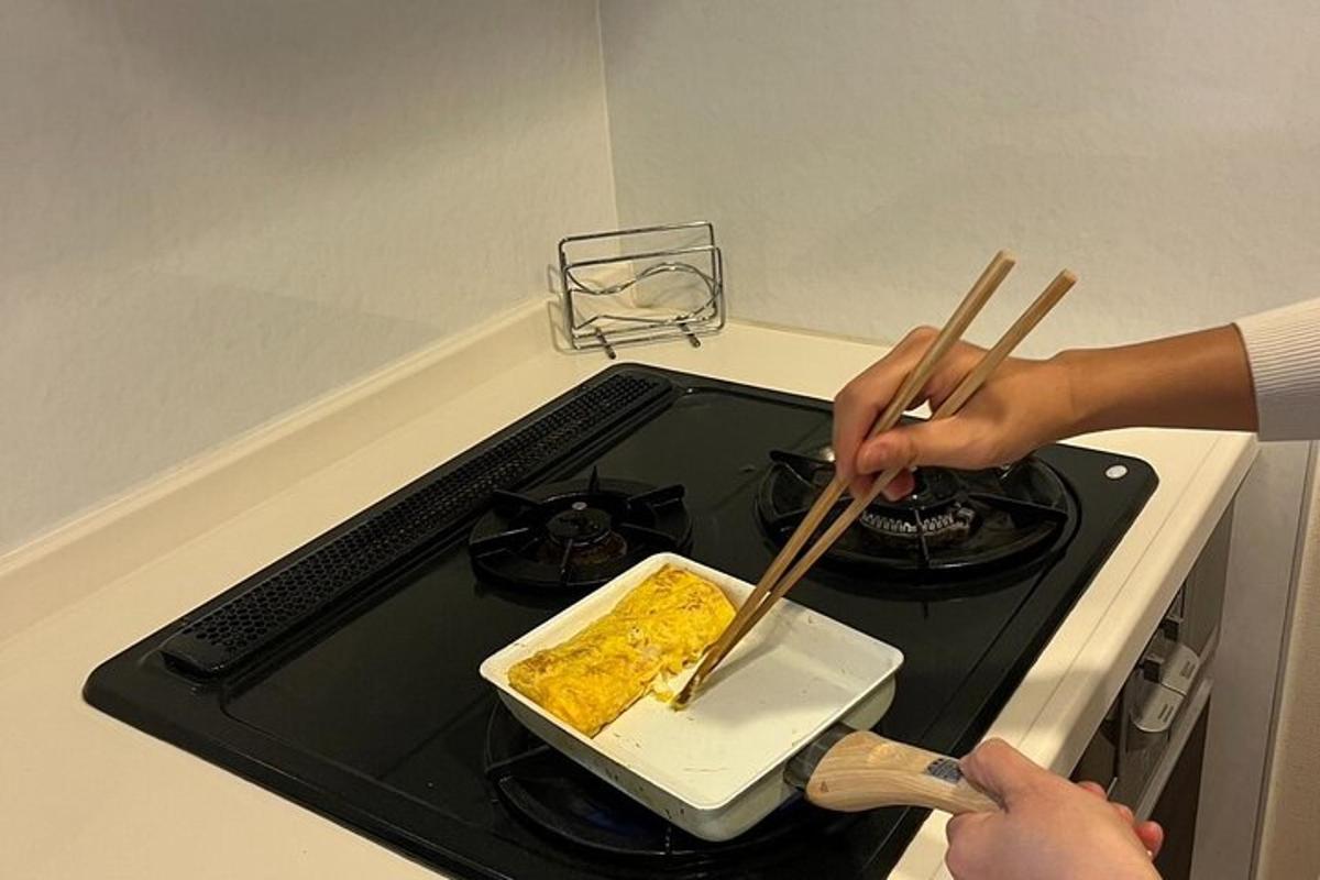 egy személy evőpálcikával készít ételt a tűzhelyen