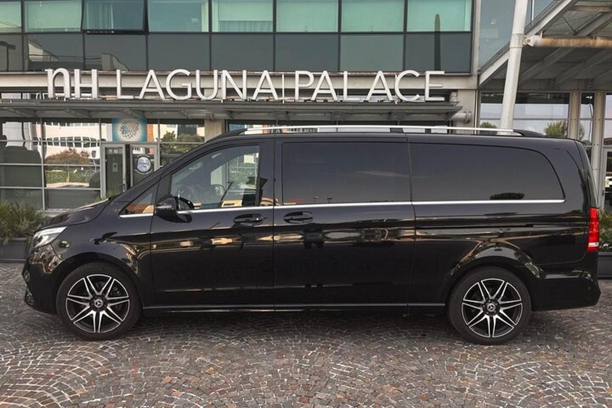 musta pakettiauto pysäköitynä rakennuksen eteen