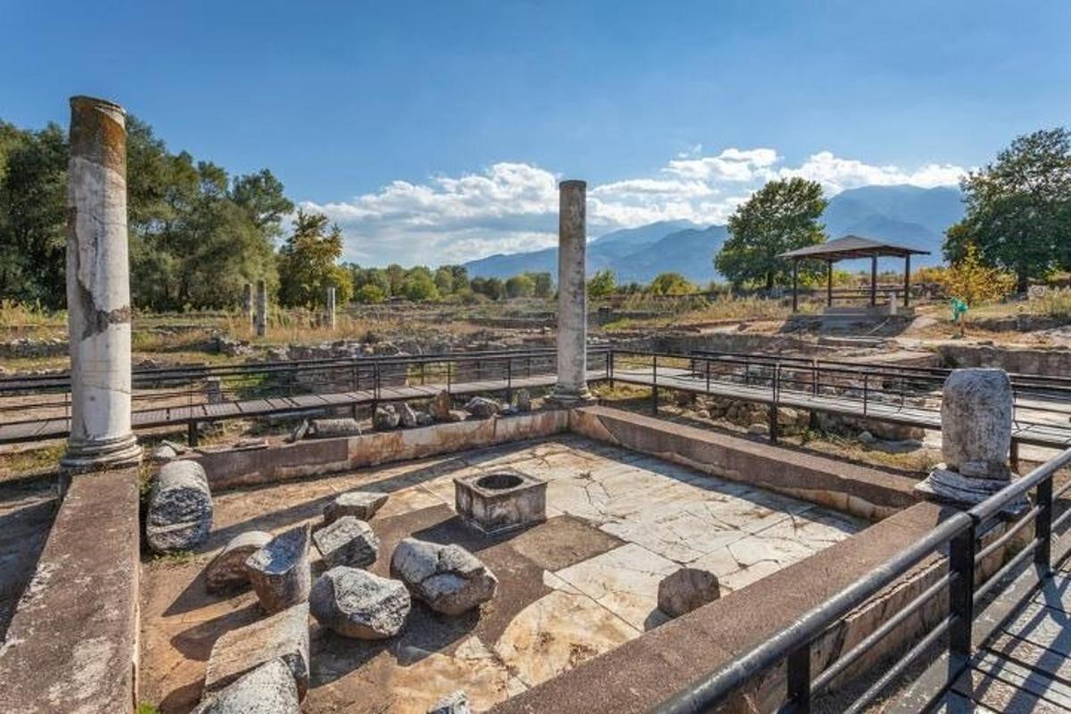 Ένα αμφιθέατρο σε αρχαία ερείπια με βουνά στο φόντο