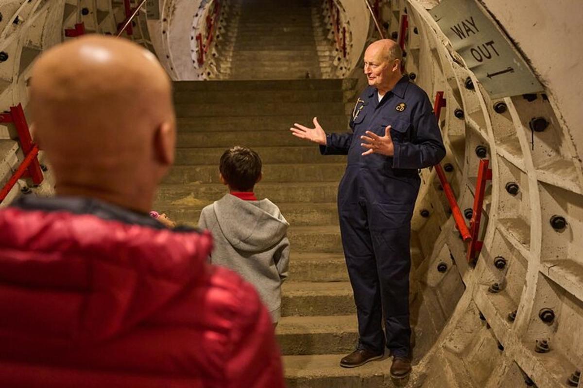 un uomo in uniforme in piedi sulle scale che parla con la gente