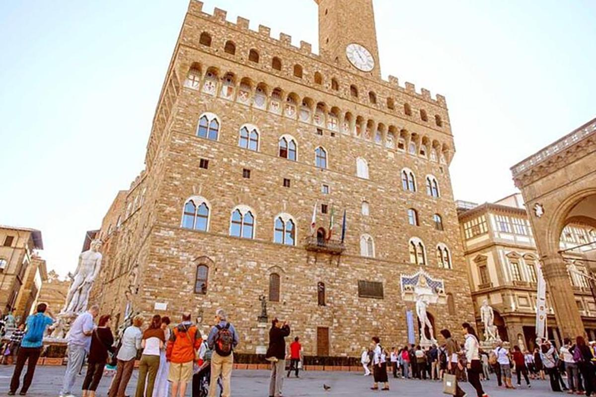 un grup de persones dretes davant d'un edifici amb una torre del rellotge