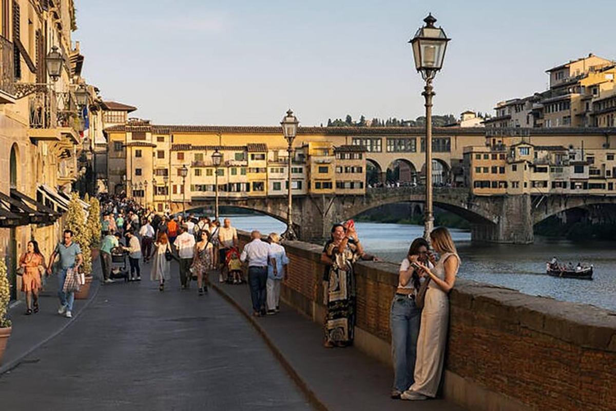 una multitud de gent caminant per un pont sobre un riu