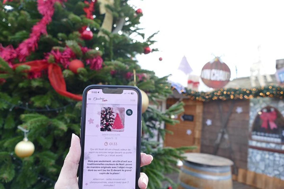 una persona che tiene in mano un telefono cellulare davanti a un albero di Natale