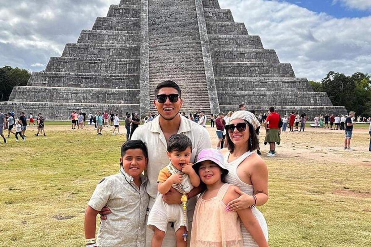 a family posing in front of a pyramid