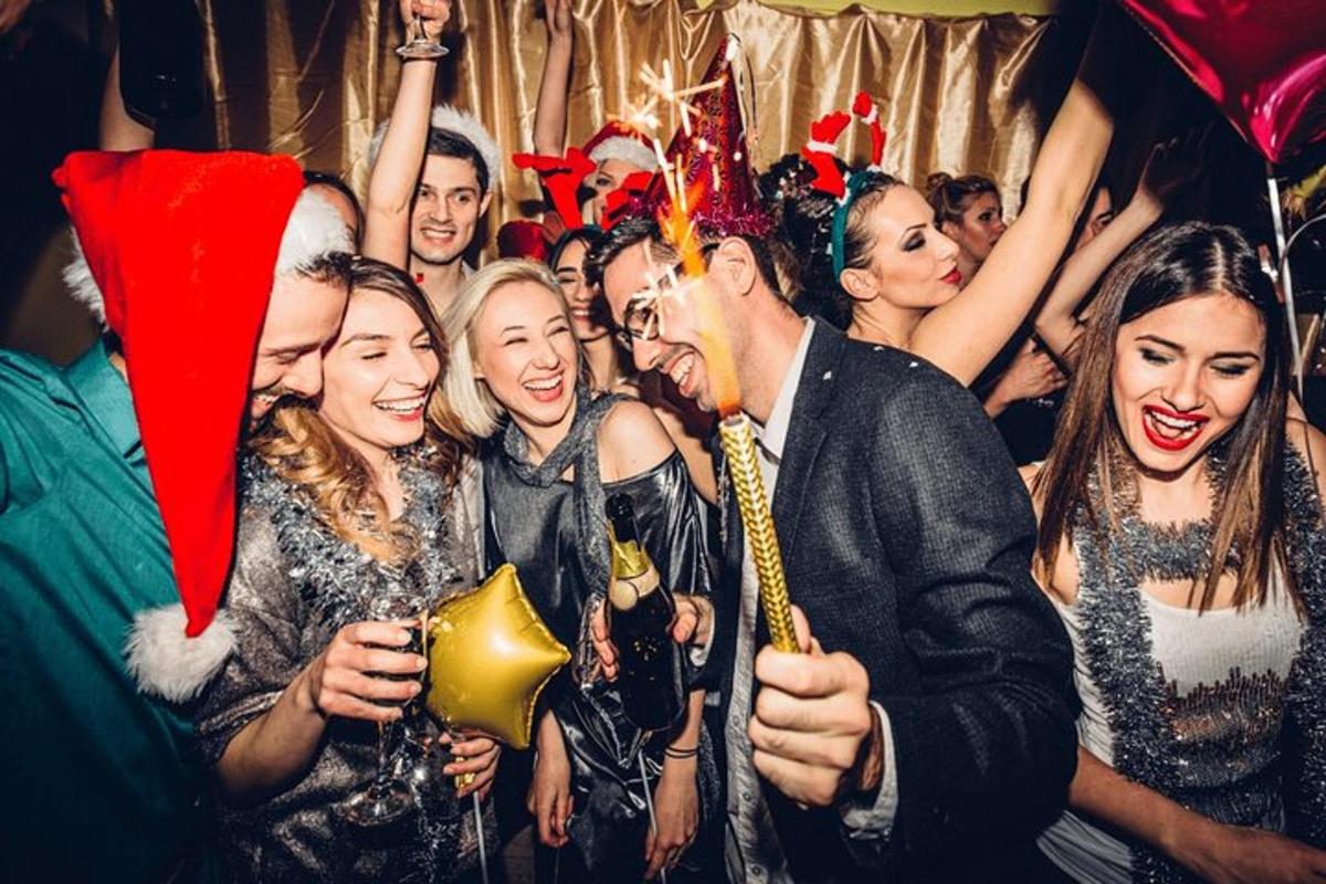 un gruppo di persone a una festa che indossano cappelli natalizi