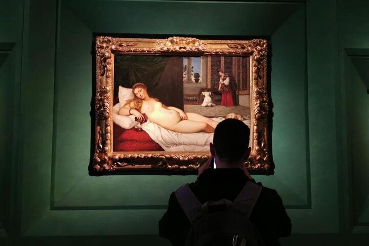 美術館で絵画の写真を撮っている男性