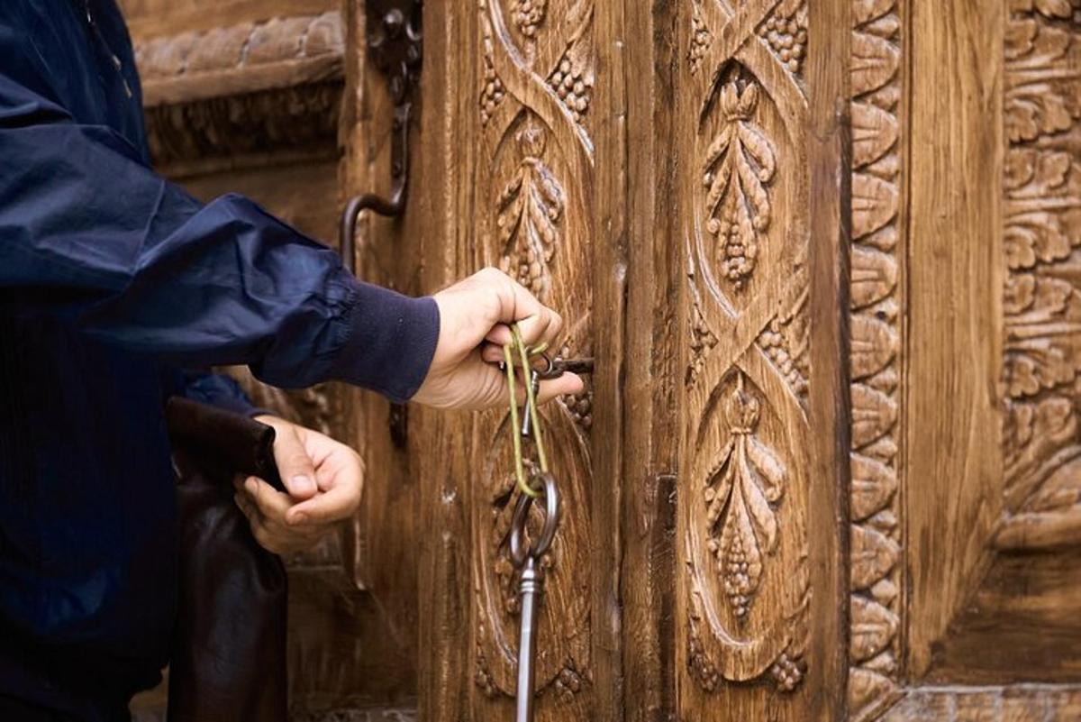 uma pessoa destrancando uma porta de madeira com uma chave
