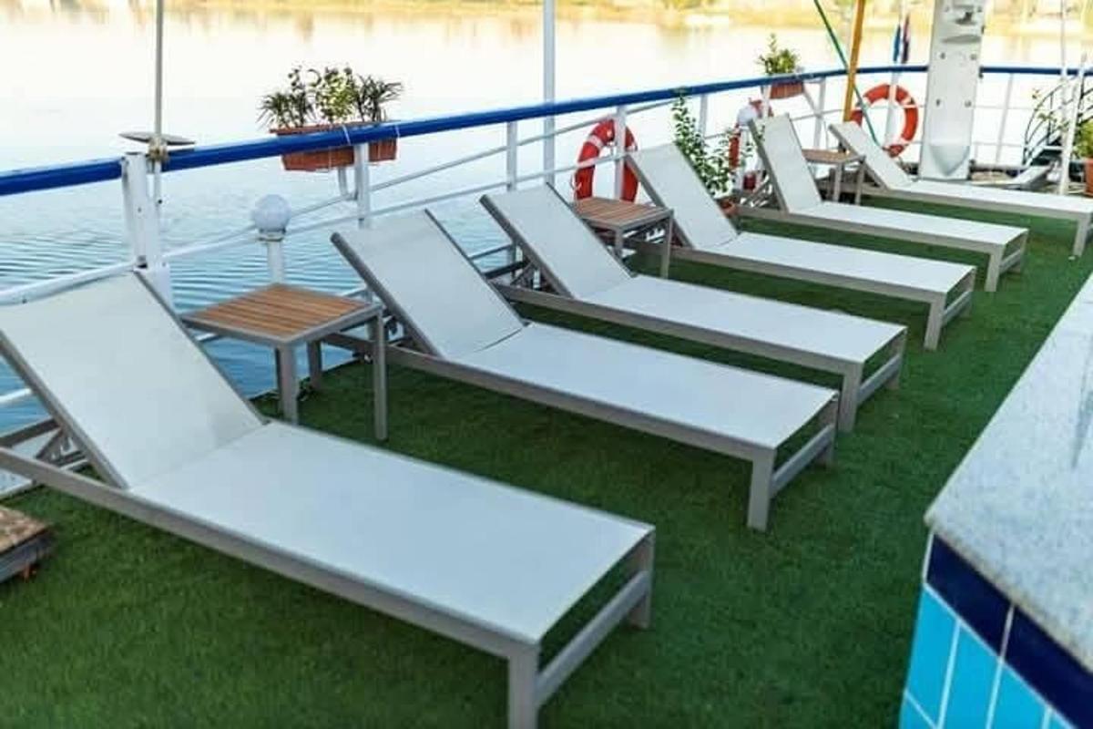 a row of white lounge chairs on a cruise ship