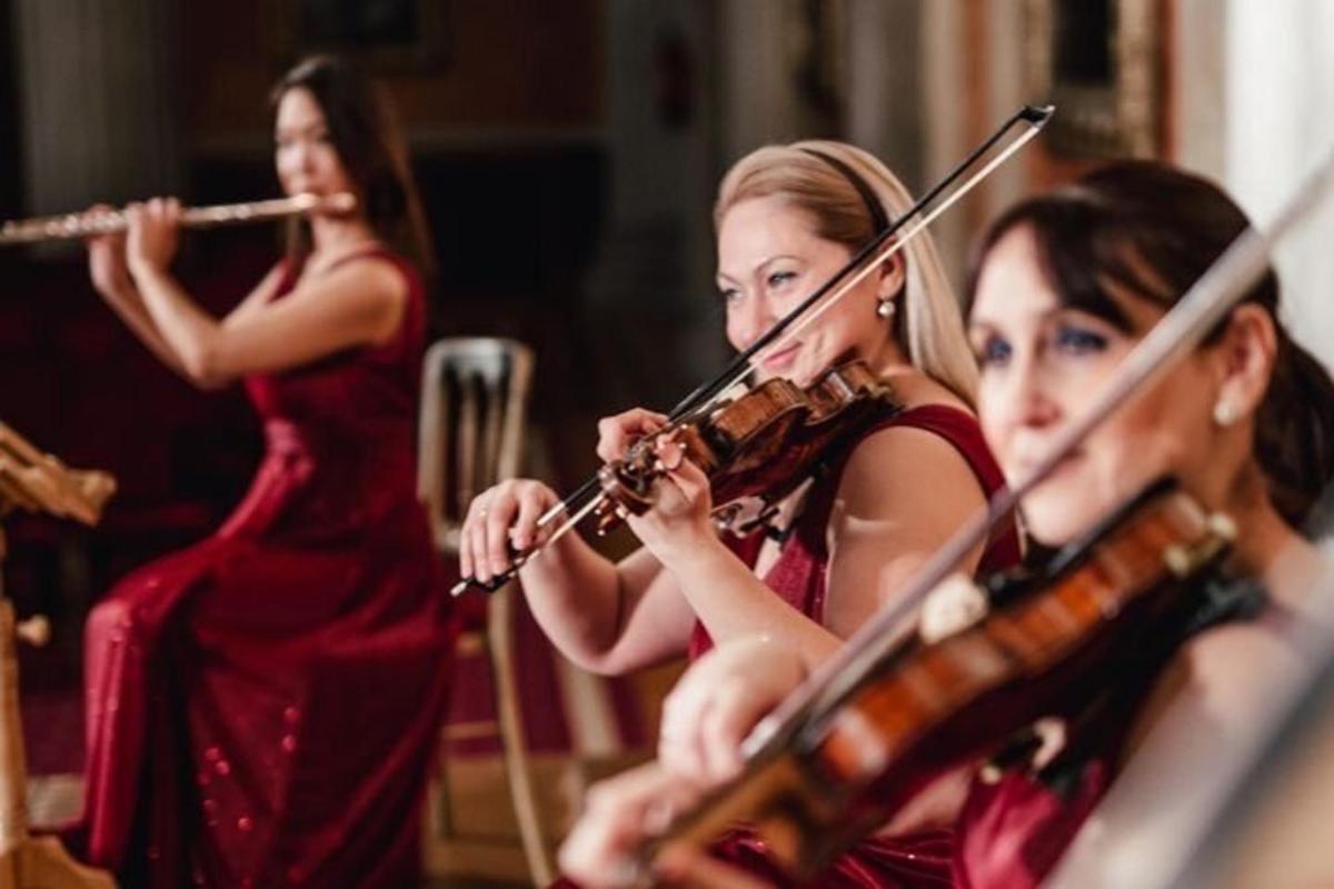 dvě dívky hrající na housle v orchestru