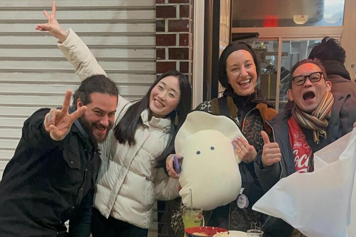 a group of people posing for a picture with a pig balloon