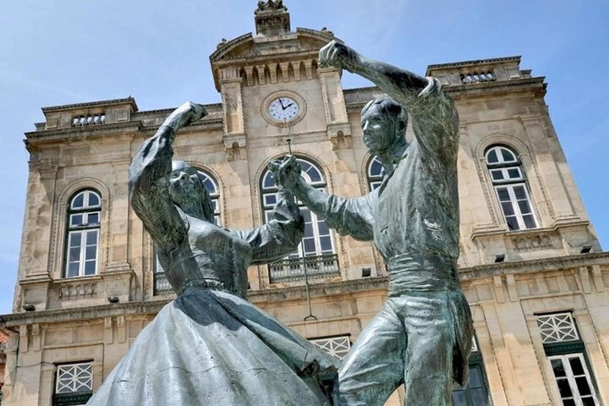 una statua di fronte a un edificio con una torre dell'orologio