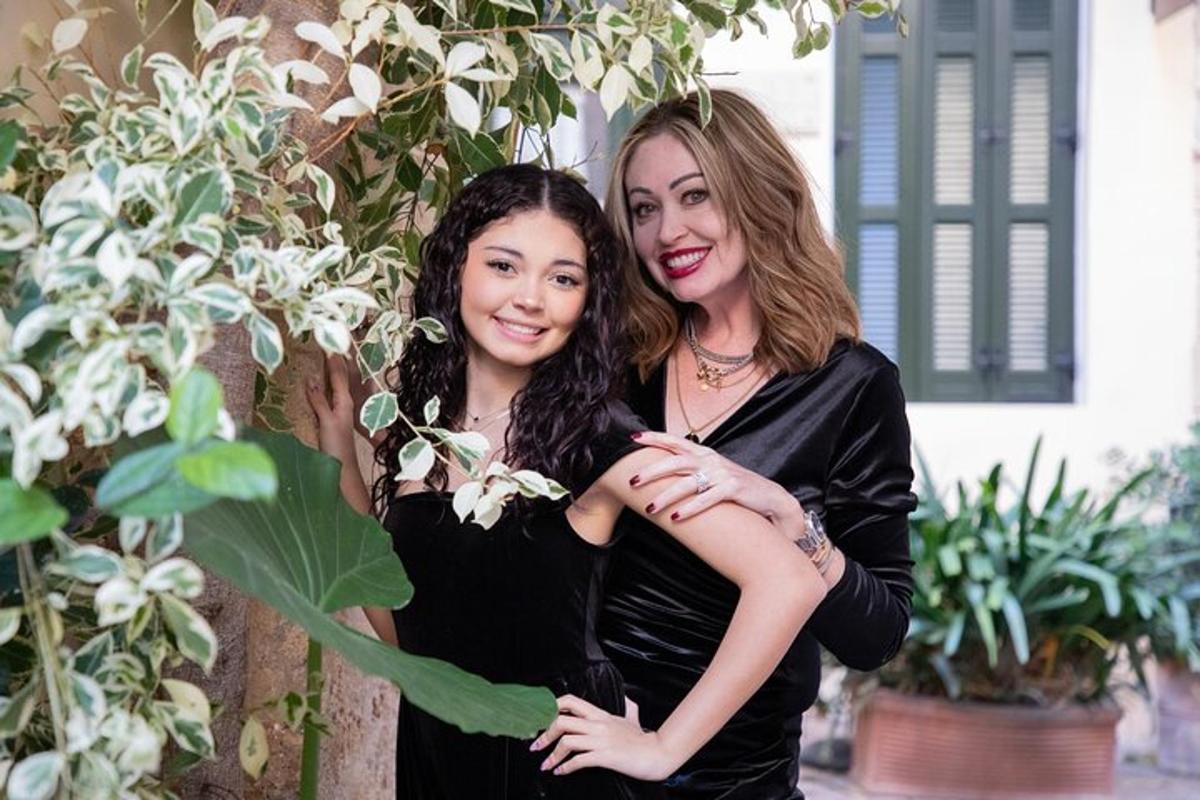 due donne in abiti neri posano per una foto