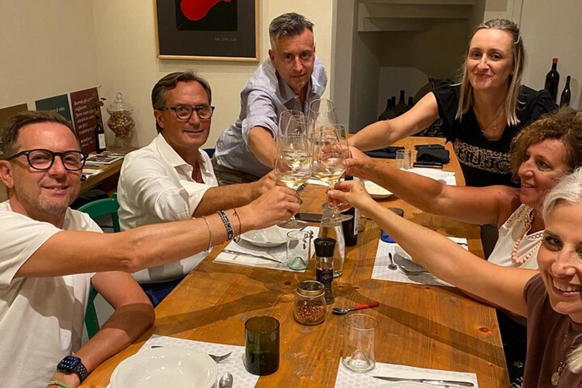 un groupe de personnes assises autour d'une table buvant du vin