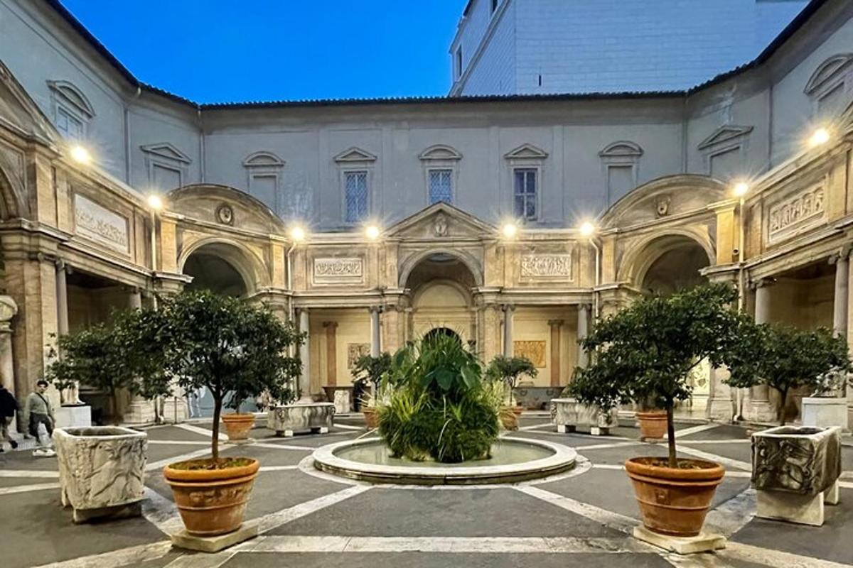 a large building with potted trees in a courtyard