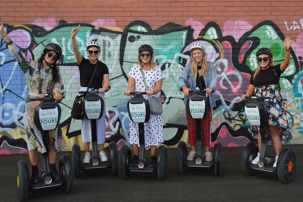 a group of women riding segways in front of a wall