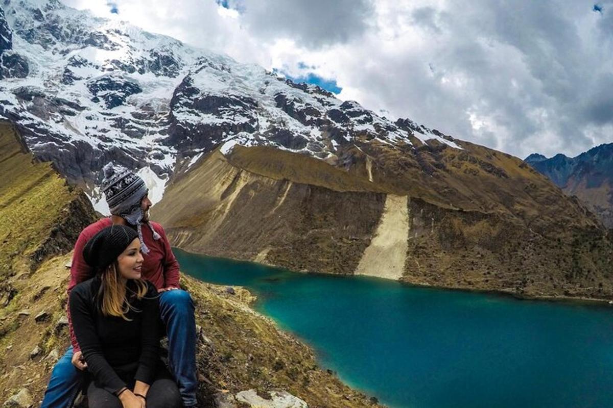 pasangan yang duduk di atas gunung dengan tasik