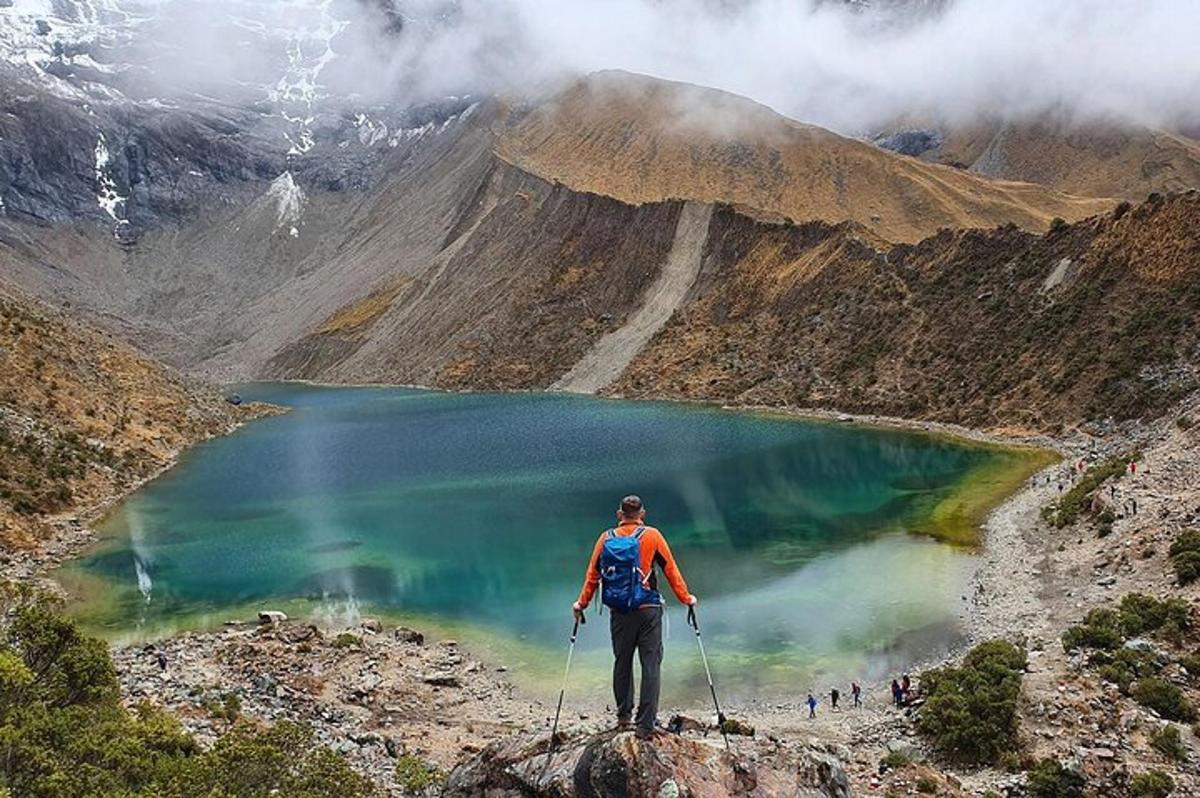 seorang lelaki berdiri di atas gunung melihat tasik