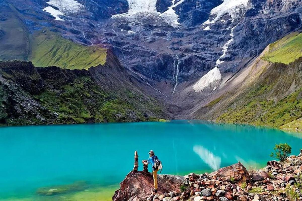 sekumpulan orang berdiri di atas gunung yang menghadap ke tasik