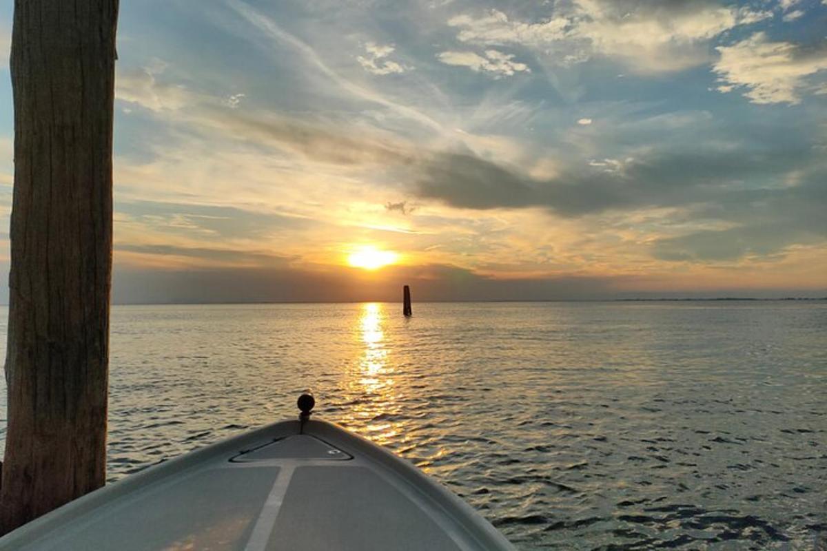 a view from the front of a boat in the water at sunset
