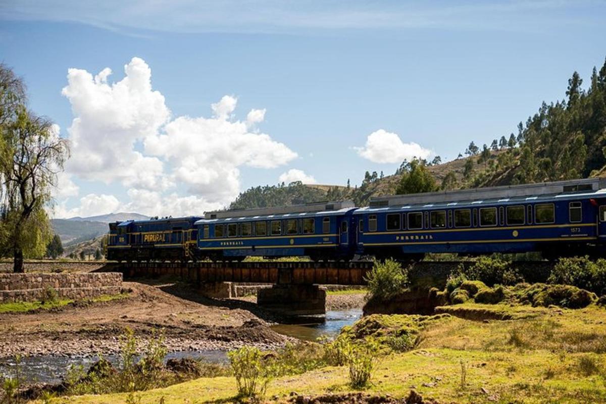 un tren azul cruzando un puente sobre un río