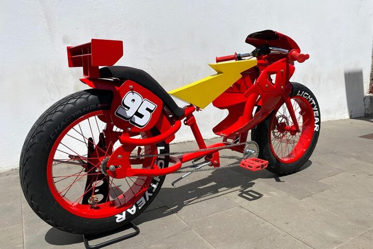 raudonas ir geltonas motociklas, pastatytas prie sienos