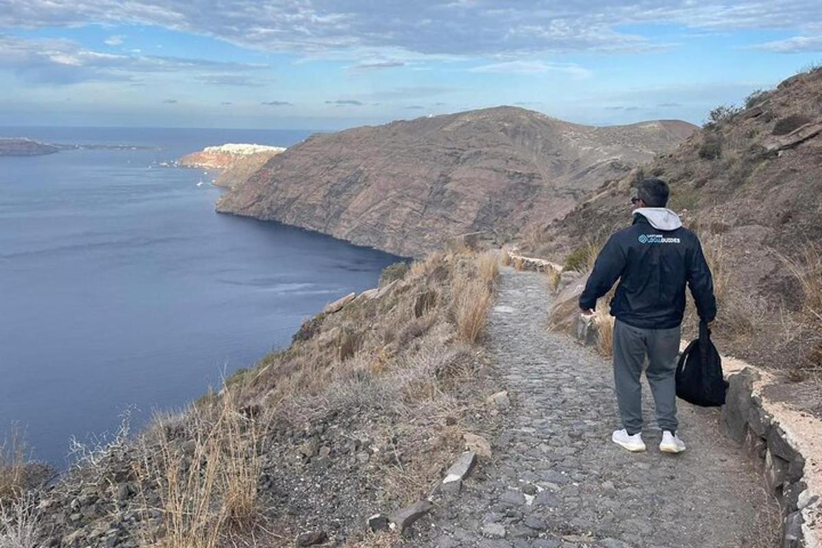 isang lalaking nakatayo sa isang burol na nakatingin sa karagatan