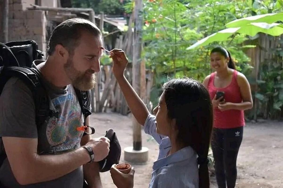 sekumpulan orang berdiri di sekeliling seorang lelaki memberi makan kepada seorang wanita