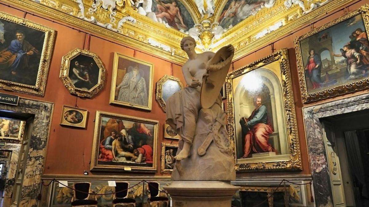 Una estatua en una habitación con pinturas en la pared.