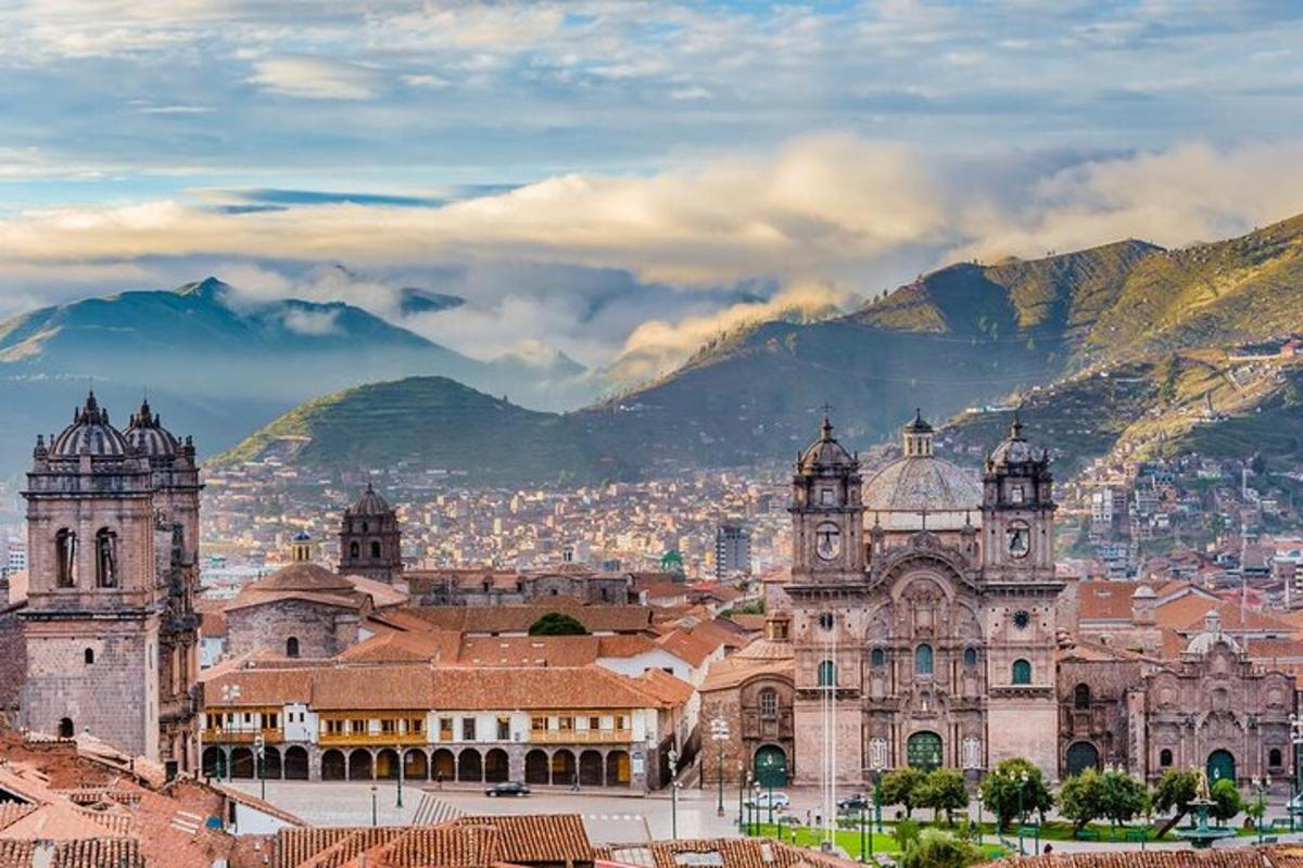 a large building with a city and mountains in the background