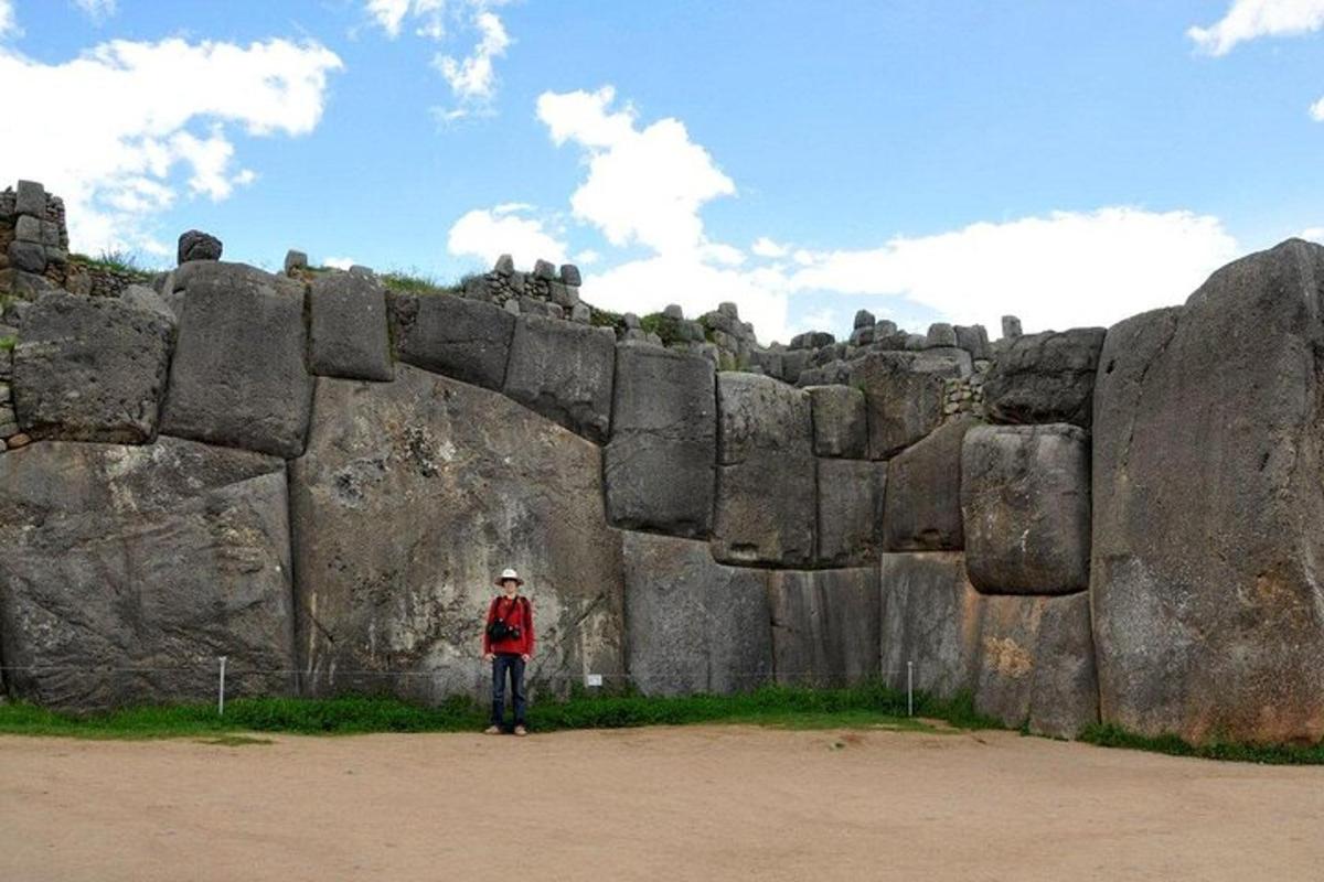 a person standing in front of a large rock wall