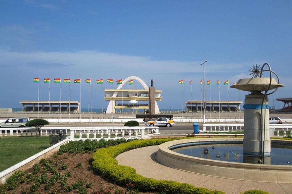 a park with a fountain and a building with flags