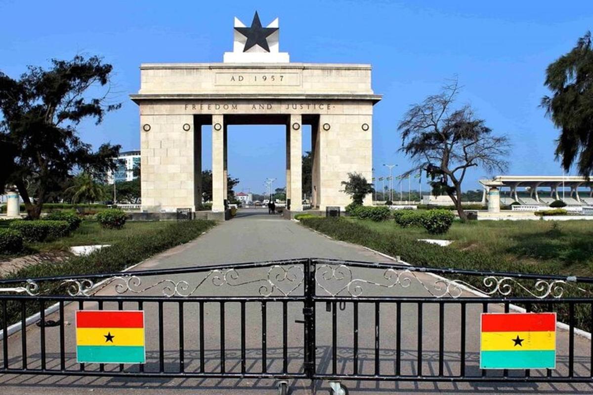 a large monument with flags in front of a gate