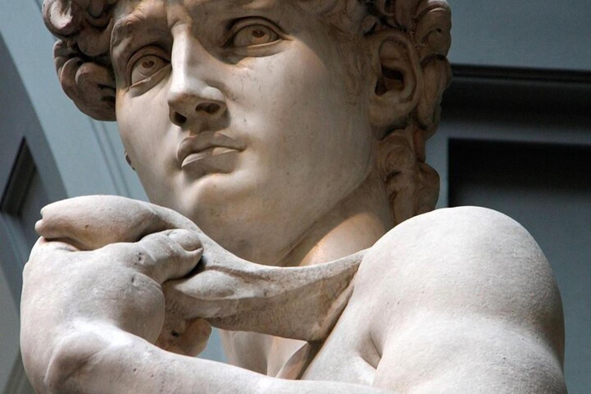 Una estatua blanca de una mujer con la mano en el hombro.