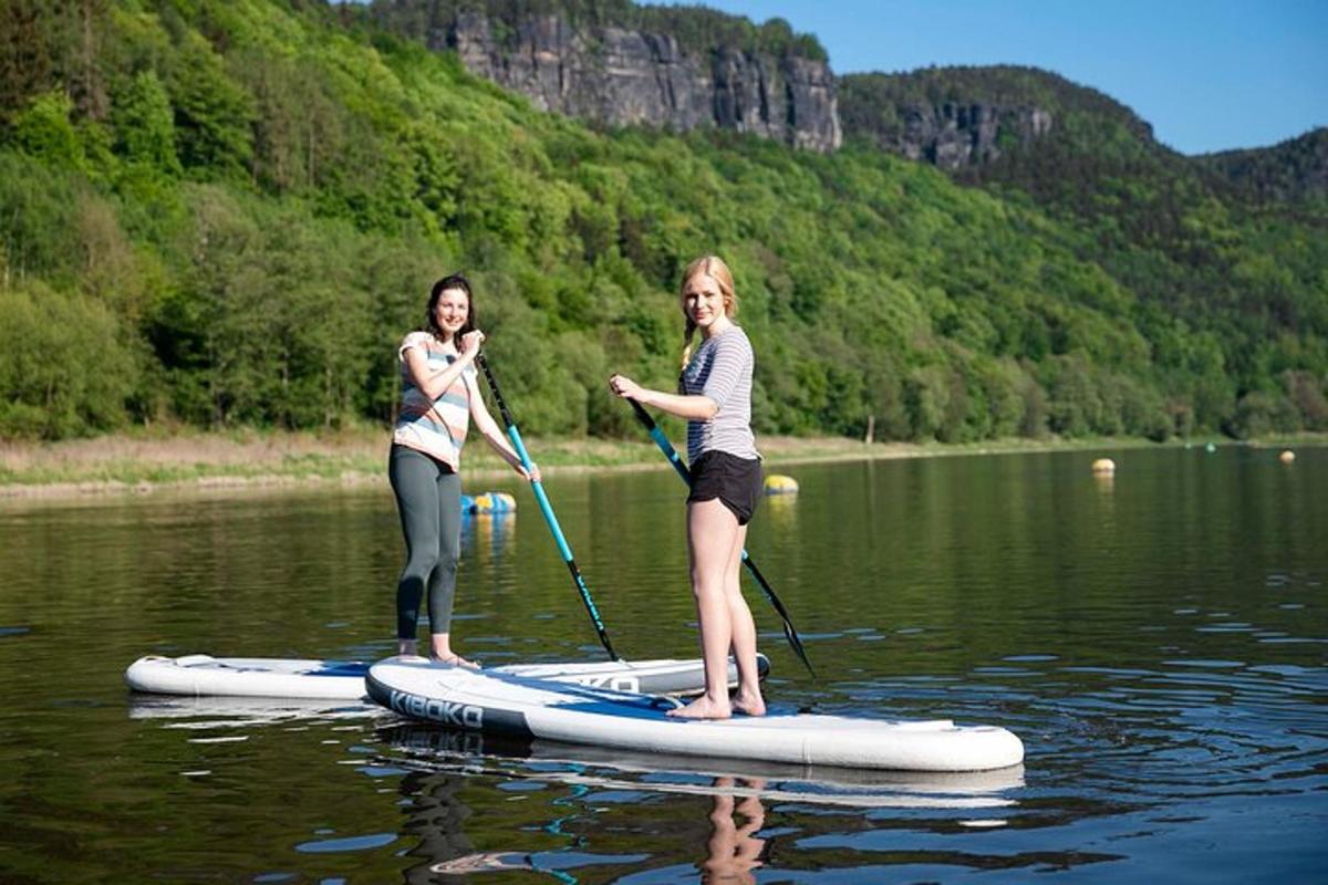 dues dones en una taula de paddle surf a l'aigua