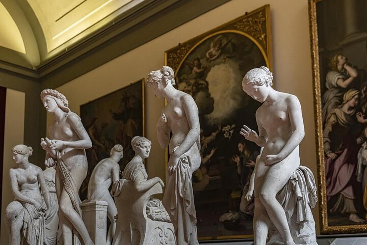 絵画のある部屋に置かれた白い彫像の群れ