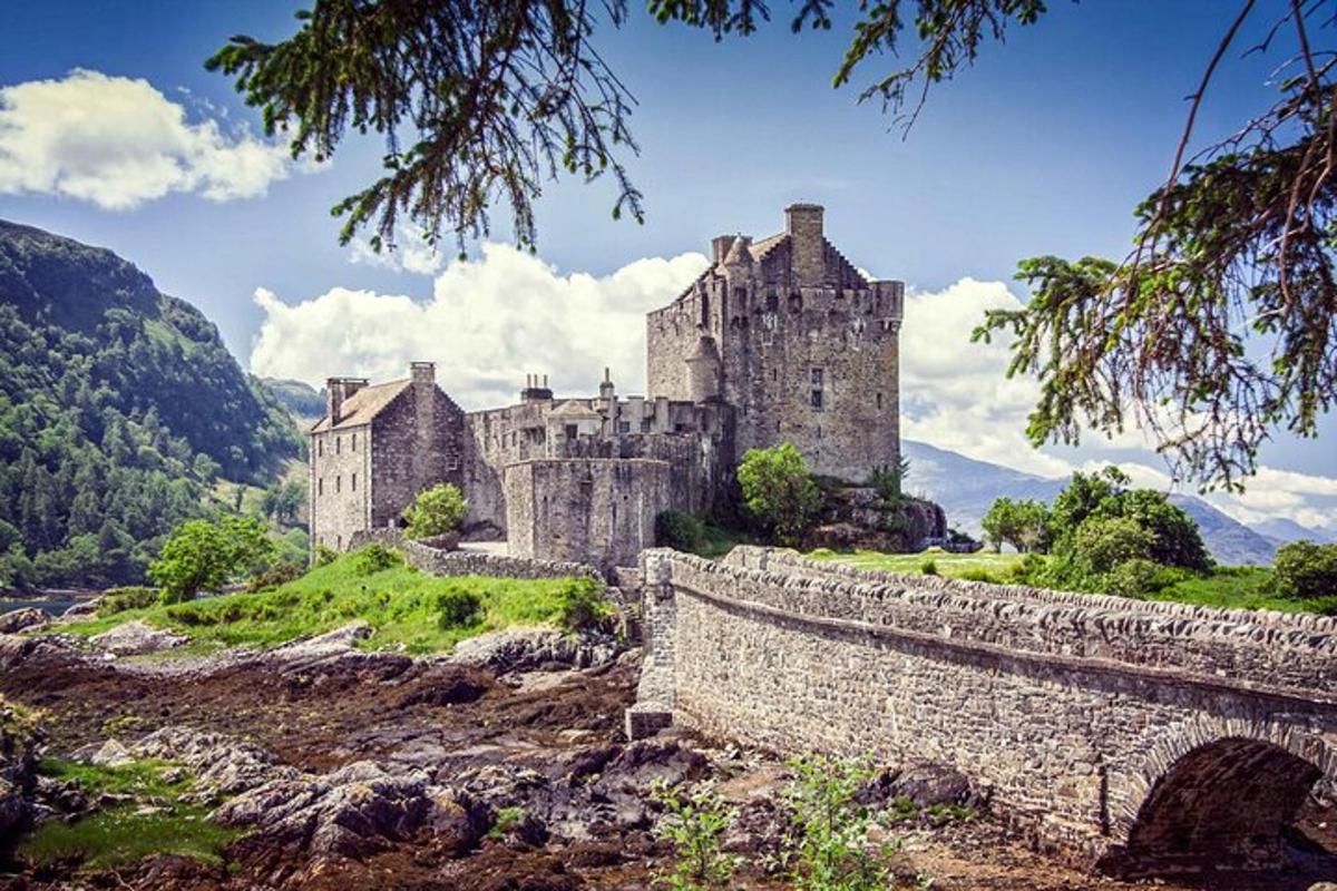 an old castle on a hill with a bridge
