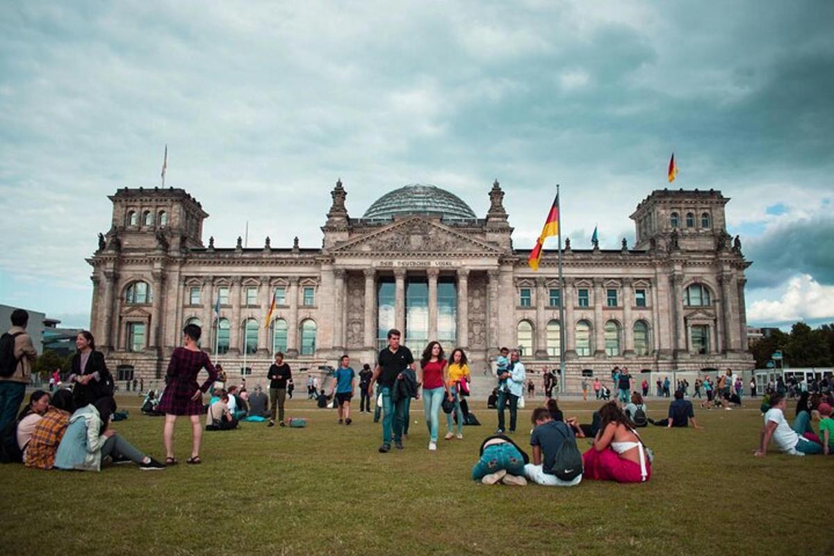 a group of people sitting on the grass in front of a building