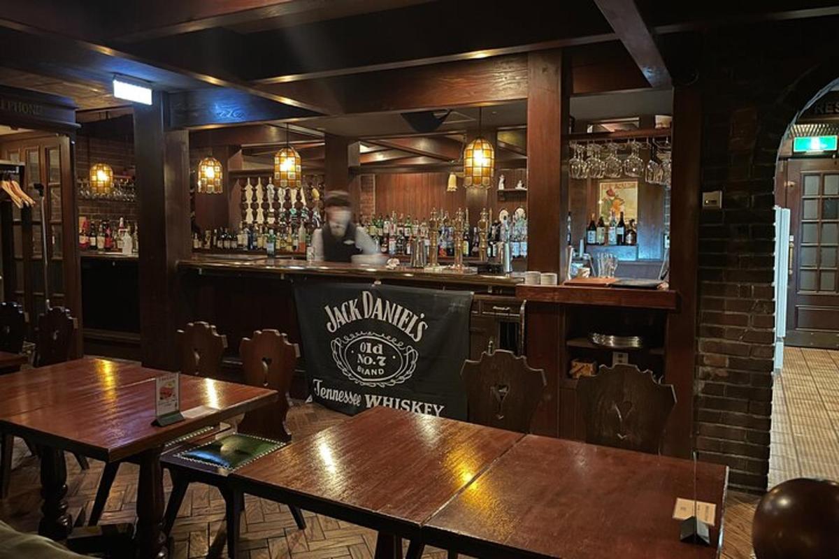 bar z lesenimi mizami in moškim za šankom