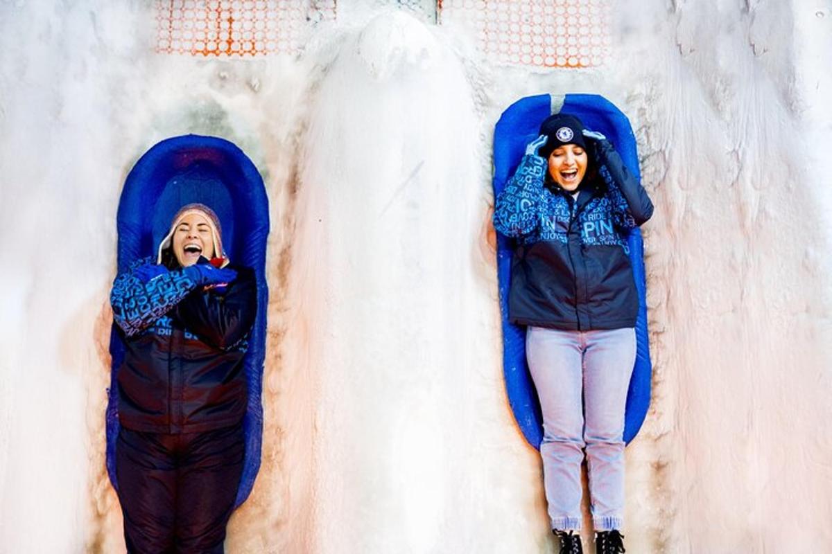 two people laying on a slide in the snow