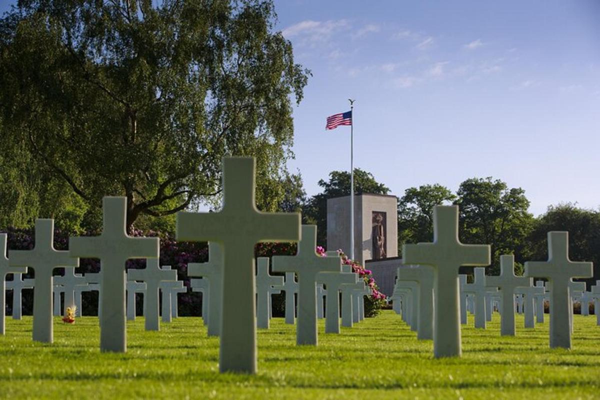 eine Reihe weißer Kreuze auf einem Feld mit einer Flagge