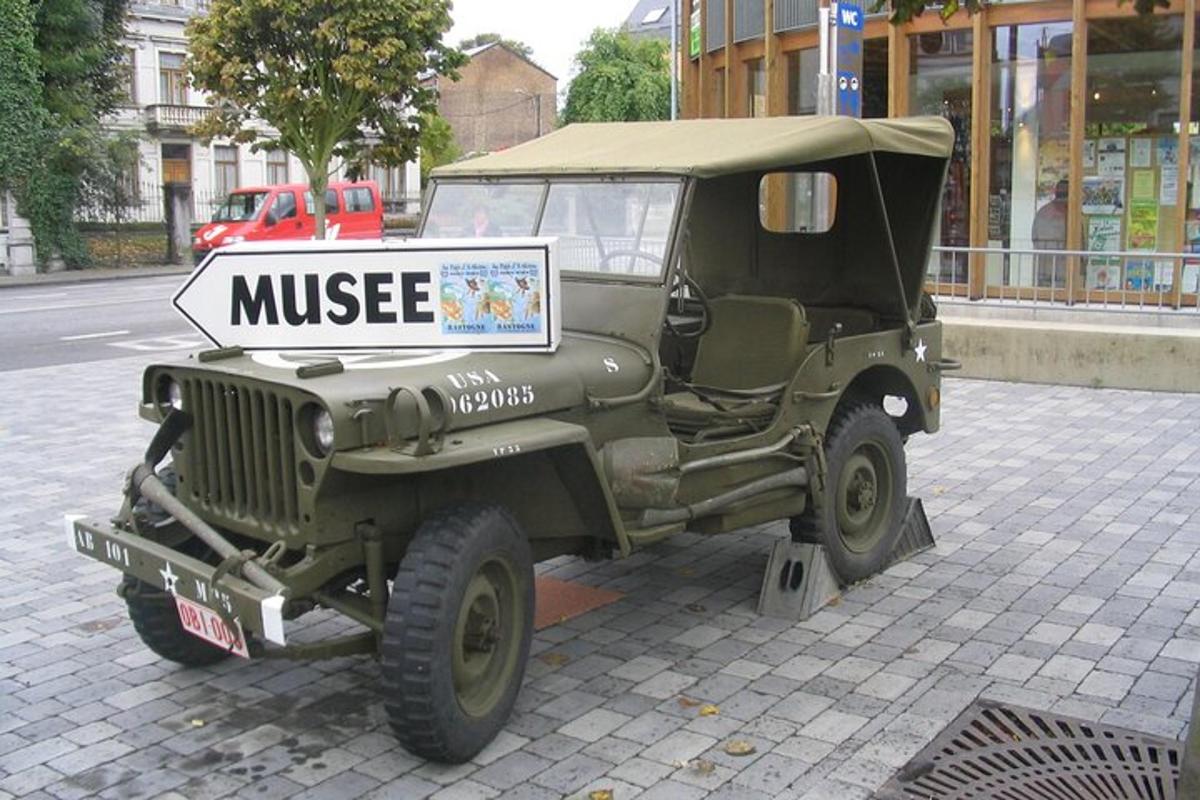 ein grüner Jeep mit einem Schild auf einer Straße geparkt