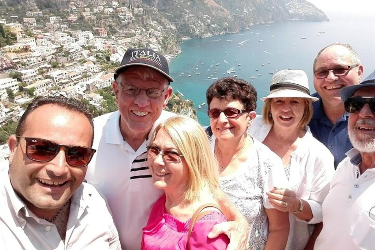 un grup de persones posant per a una foto davant de l'oceà
