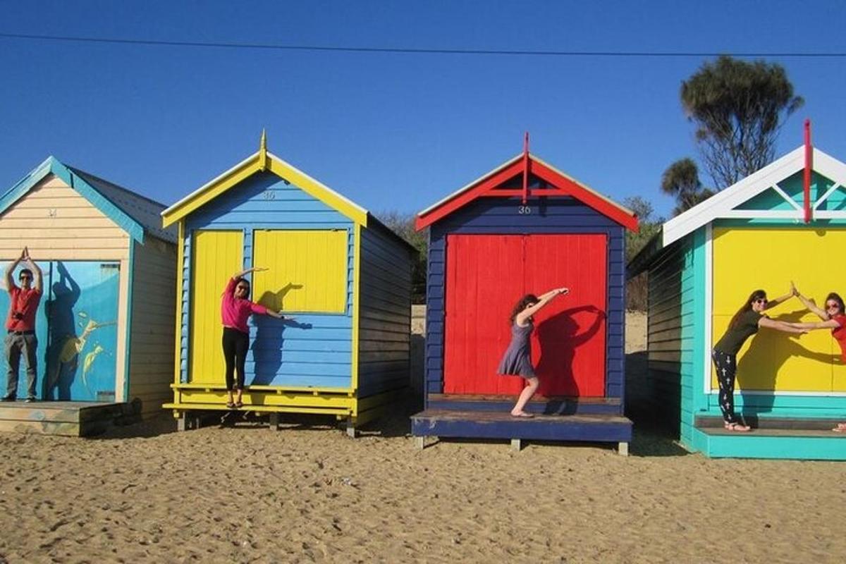 a group of colourful beach huts on the beach